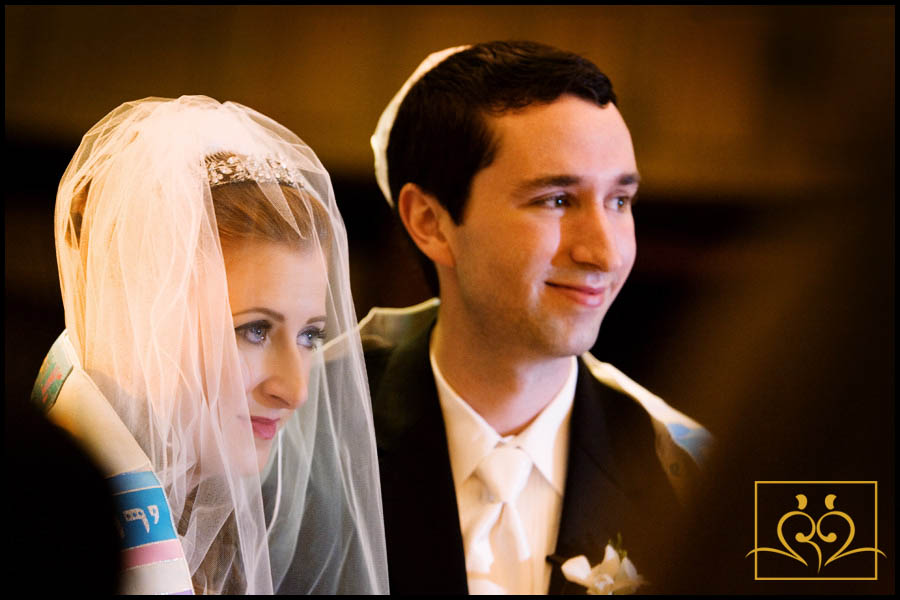 Rina and Jeffrey wrapped in a tallit during their wedding ceremony.