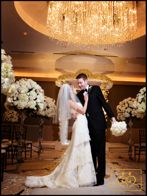 A dramatically lit wedding portrait in front of a stunning chuppah!